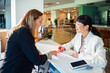 © Marko Geber - Businesswomen signing contract at reception desk in modern office