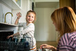© Davor - Mother and daughter loading a dishwasher in a home kitchen