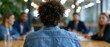 © Olga Ко - Employee viewed from behind sitting at a conference table while being completely ignored by colleagues during a meeting. Concept of workplace exclusion, isolation, and discrimination in a modern corpo
