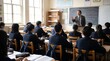 © CuteBee - Teacher standing in front of blackboard giving lesson to class of students in uniform sitting at desks in traditional school classroom with natural window light