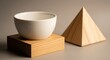© Visual - Minimalist still life with white bowl on wooden block and wooden pyramid on gray background
