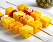 © theshooter - Brochetas tropicales de frutas frescas con mango, piña, papaya y maracuyá en primer plano gastronómico sobre fondo blanco, alimentacion saludable, colorida y refrescante para verano