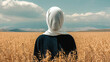 © Concept Photo Studio - Femme portant un foulard blanc sur la tête dissimulant son visage, dans un champ de blé