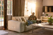 © Wavebreak Media - Diverse couple in casual clothes reclining on light leather sofa in living room, sharing smartphone