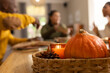 © Wavebreak Media - African American friends chatting at table with pumpkin in wicker basket and lit candle, copy space