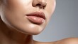 © harryaishi - Close-up of glossy lips and surrounding skin, well-lit, smooth texture, against a gray background