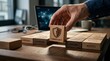 © mohdfaizal - Hand placing cybersecurity shield block on wooden table