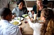 © Rawpixel.com - Four people enjoying a meal together at a cozy restaurant table.