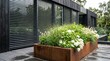 © H & F - Modern house exterior with rusty steel planter box filled with white hydrangea flowers and grass
