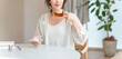 © buritora - A stylish woman relaxing at the dining table in the living room during teatime.