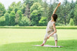 © buritora - Young Asian women doing yoga, Pilates, and stretching in a park.