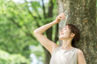 © buritora - A woman drinking water in the forest (hydration, mineral water, sodium)