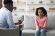 © Prostock-studio - Worried Young African American Girl Participating In Counseling Session With Male Therapist. Engaged In Discussing Thoughts And Feelings While Sitting In A Comfortable Office Setting. Healthcare