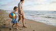 © Suryani - Mother and Daughter Walking on Beach with Beach Ball.