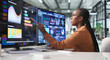 © Andrey Popov - Young African Businesswoman Analyzing Real-time Financial Data