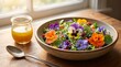 © visualdalamframe - A vibrant Fennel salad with salad with edible flowers  flowers and herbs and microgreens on a table indoors  next to a glass with a spoon in bright background
