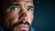 © Larisa AI - A portrait of a handsome man with a beard and striking blue eyes. His intense, thoughtful gaze invites viewers to ponder his story, framed in moody lighting.