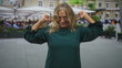 © Krakenimages.com - Senior woman pointing thumbs to chest on street plaza wearing green dress, smiling with eyes closed and raised hands; pride self assertion.