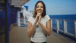 © Krakenimages.com - Woman clasping hands on cruise deck building with interlaced fingers and eyes closed in gentle gesture; serenity reflection.
