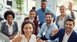 © Chandara - A diverse group of business professionals, including men and women, are smiling and waving in a modern office setting.
