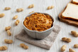 © Liudmyla - Crunchy Peanut Butter in a Bowl with Bread, side view.