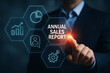 © Tanu - Man interacting with a digital display showing annual sales report data analysis