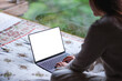 © Farknot Architect - Mockup image of a woman working and typing on laptop computer with blank desktop white screen on the bed at home