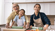 © fizkes - Beautiful multi-generational relatives women cooking in modern kitchen on family holiday, preparing homemade pastries, laughing, having fun, posing for camera, enjoy communication, cookery together