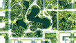 © Karina Zoya - aerial view of lush green park with lakes and pathways in urban setting during daytime
