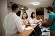 © Zoran Jesic - Healthcare professionals assisting patient at clinic reception desk