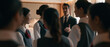 © Olga Ко - Male hotel manager leading a daily briefing with a team of uniformed hospitality staff in a luxury room. Front desk and housekeeping team training on premium guest service standards.