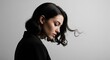 © Platon - Profile view portrait of a young woman with short or medium-length dark wavy hair looking down thoughtfully against a plain grey background