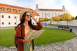 © Home-stock - Woman tourist sightseeing, walking in town with paper map, copy space