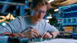 © Maksym Tereshchenko - Biomedical engineering student assembling neural dust wireless recording prototype circuit board in university innovation lab industrial workspace, oscilloscope probes attached to miniaturized recei