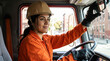 © Tatiana - Hispanic female firefighter in orange uniform driving fire truck with determination on city street
