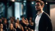 © FANTASY WORLD - Speaker gesturing during a professional presentation delivers a keynote speech to an attentive audience in a conference hall.