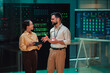 © Zamrznuti tonovi - It engineers discussing server performance in data center, analyzing information on a dashboard screen
