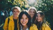 © Anuson - Group of happy young friends smiling brightly outdoors in yellow jackets
