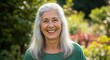 © Isolatted picture - A smiling, happy, healthy senior woman with long gray hair enjoying the outdoors in a garden setting.