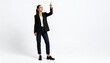 © sandi - Professional business woman in a dark blazer pointing her finger upward at empty space on a white background
