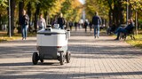 A white robot on wheels rides down a brick pathway in a park