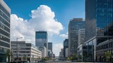 Modern cityscape with tall glass office buildings under a bright blue sky with large white clouds.