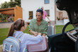 © Halfpoint - Happy family leaving home for summer vacation putting luggage in car trunk.