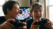 © Jian - Video Game Day brothers playing multiplayer console games together with excitement and joy at home for entertainment technology youth culture gaming friendship bonding content