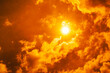 © Chandet - Dramatic blazing sun shining through fiery orange clouds during an extreme heatwave, global boiling and climate crisis concept, hot summer weather background.