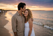 © Meow Creations - A romantic man gently kisses his female partner on the forehead while standing at a sunset beach