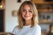 © TENphoto - Smiling young woman in casual attire posing indoors with blurred background