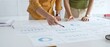 © rogerphoto - Business professionals analyzing financial reports, pointing at data points on charts and graphs lying across white desk surface