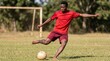 © Agnes - Footballer striking ball barefoot on outdoor grass pitch with shallow depth of field for sports equipment marketing
