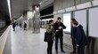 © starush - Station Platform Commuters Processing Sudden Service Update in Clean Metro